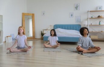 focused multiracial friends meditating in room